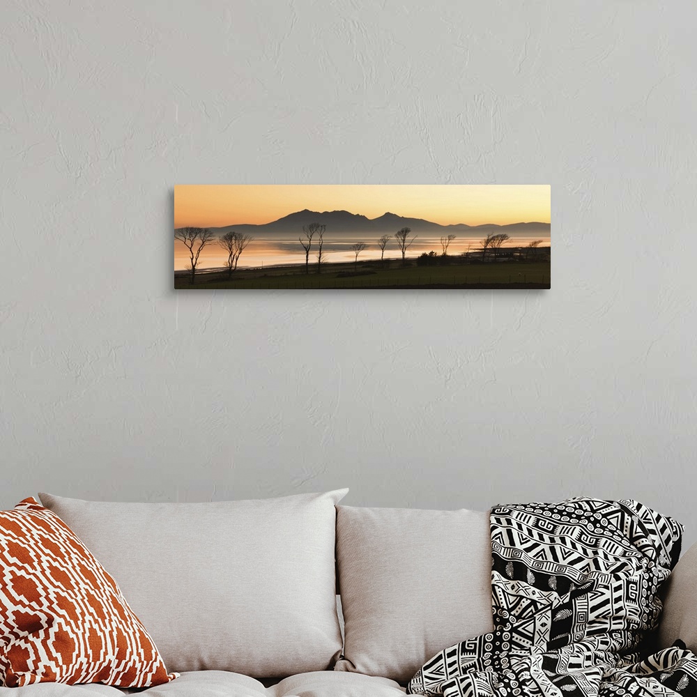 A bohemian room featuring Bare trees at west coast with mountain in background at Scotland.