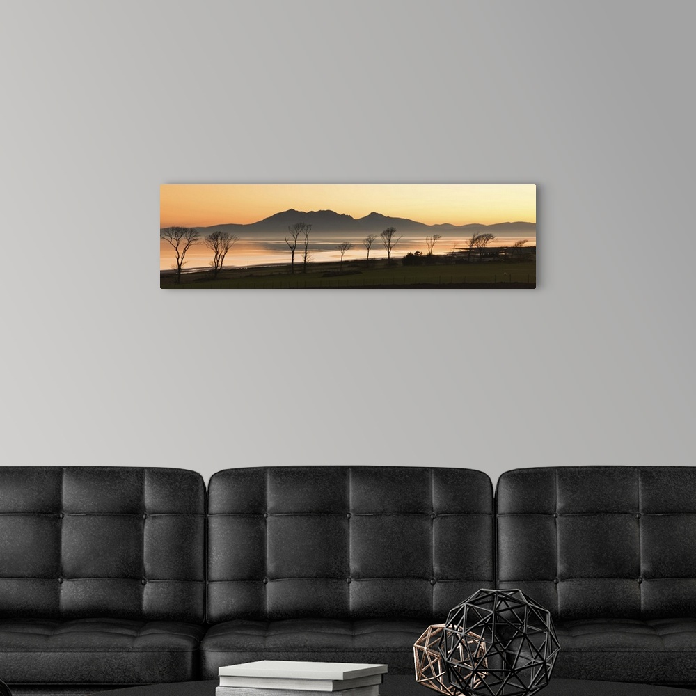 A modern room featuring Bare trees at west coast with mountain in background at Scotland.
