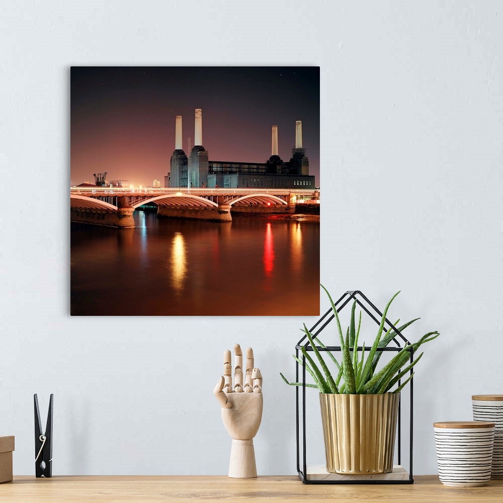 A bohemian room featuring Battersea Power Station at night with light reflections in river Thames.