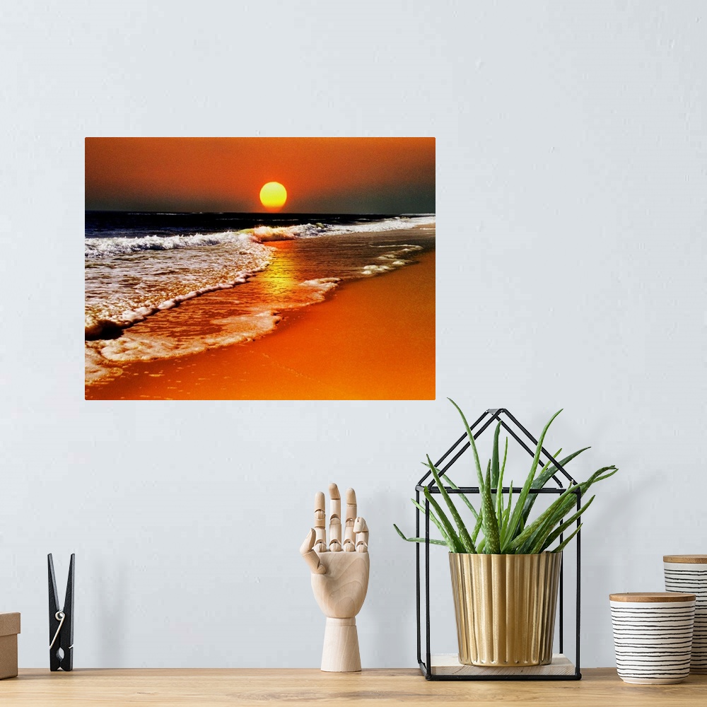 A bohemian room featuring This canvas wall art is a photograph of the sun dropping below the horizon in this landscape at t...