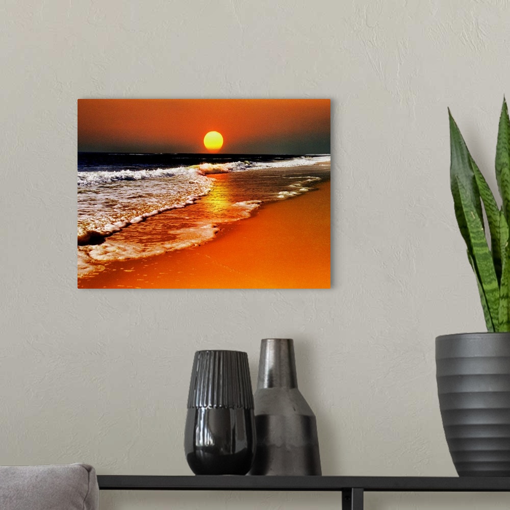 A modern room featuring This canvas wall art is a photograph of the sun dropping below the horizon in this landscape at t...