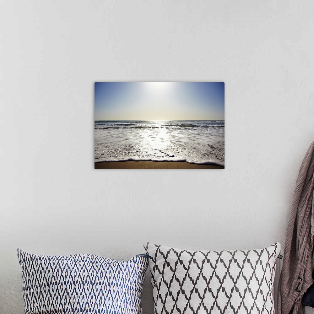 A bohemian room featuring Photograph of shoreline with sea spray and foam washing up under a bright clear sky.