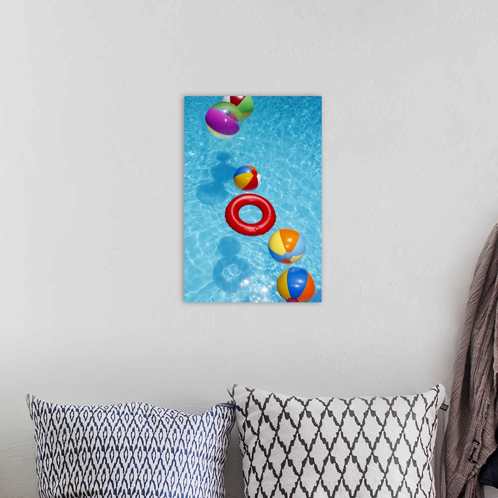 A bohemian room featuring Beachballs blowing in wind in sparkling blue swimming pool.
