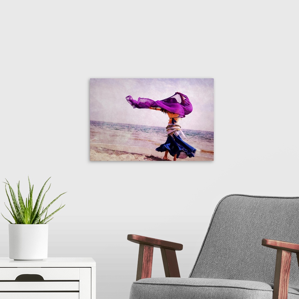 A modern room featuring A beautiful belly dancer, dancing on the Coney Island  Beach, New York.