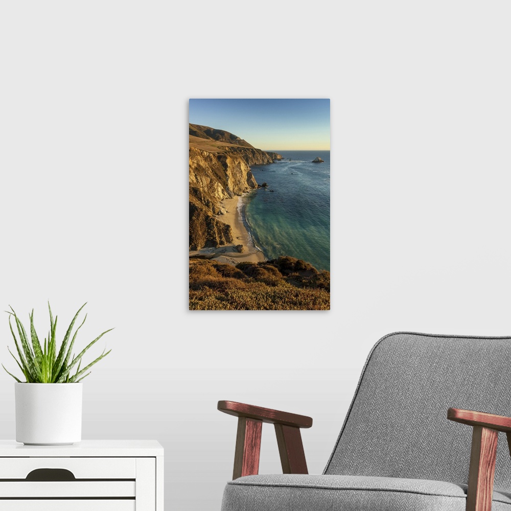 A modern room featuring A view of Bixby Creek entering the Pacific Ocean on California's Big Sur coastline at sunset look...