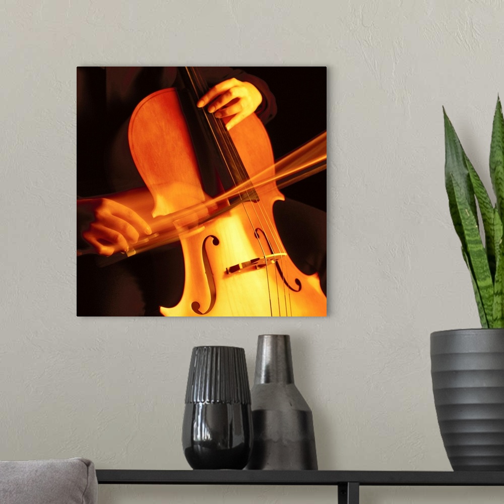 A modern room featuring blurred shot of a person playing the cello