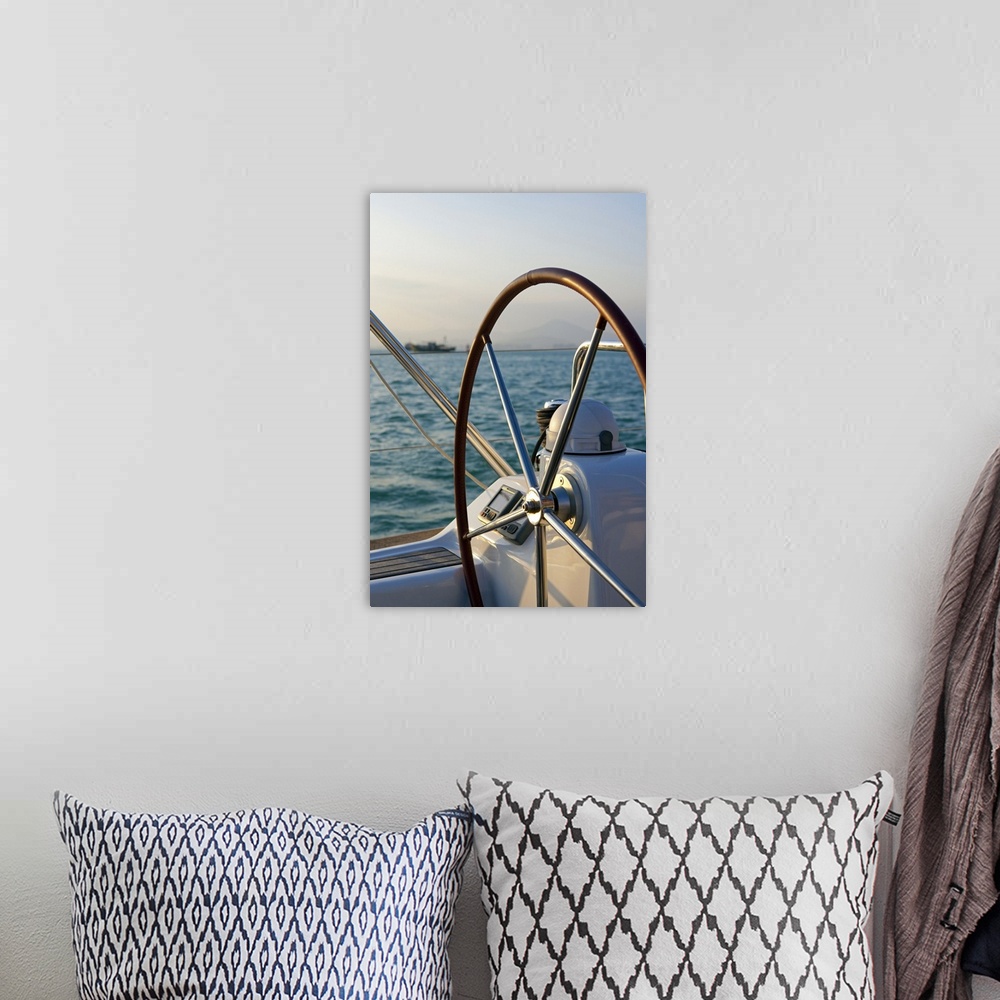 A bohemian room featuring Up-close photograph of steering wheel on sailboat with the ocean in the background.