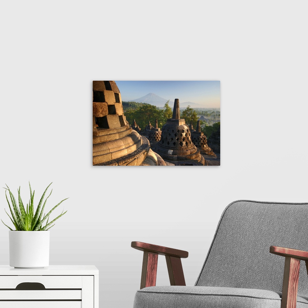 A modern room featuring Stupas on top of Borobudur temple, early morning light.  A UNESCO World Heritage site, built betw...