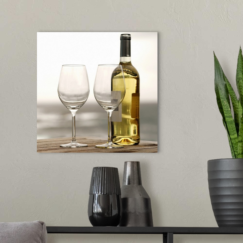A modern room featuring Square photograph on a large canvas of two empty wine glasses sitting on a wooden table, along wi...