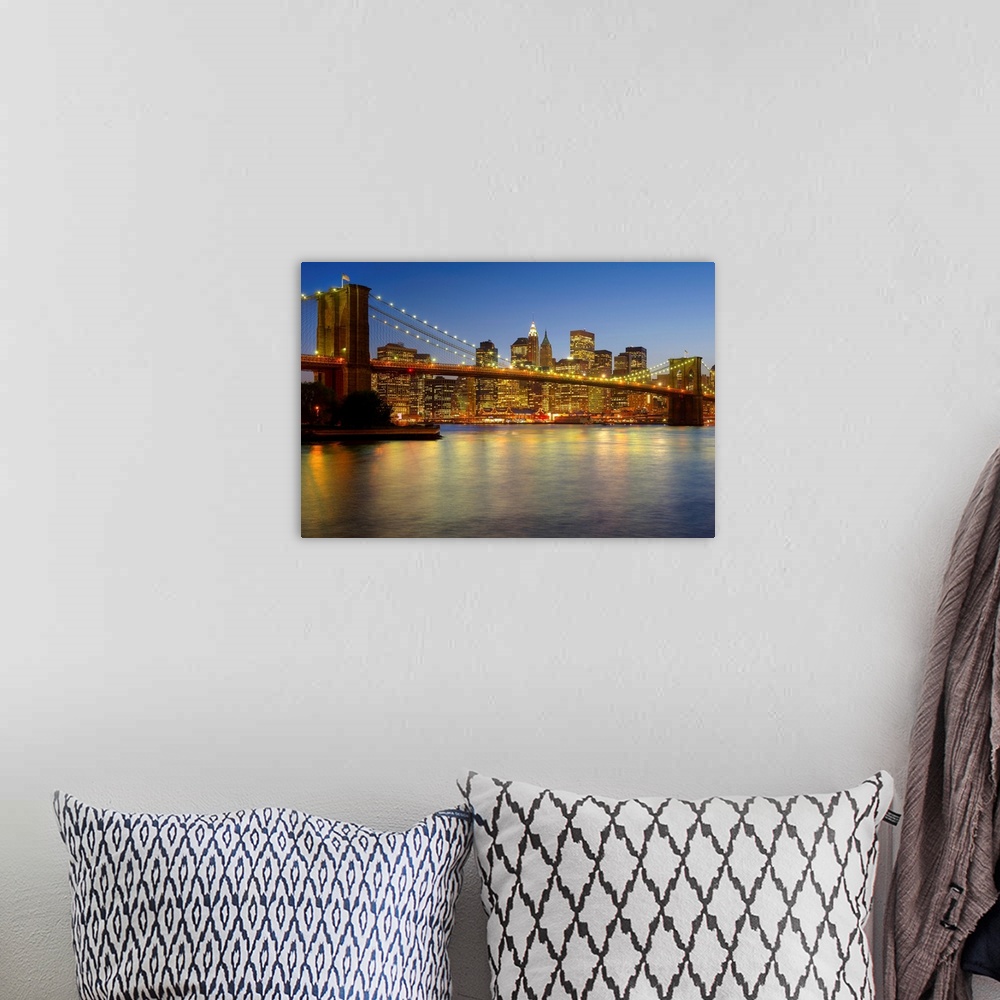 A bohemian room featuring Photograph of skyline and waterfront after sunset.  The buildings lights are reflected in the wat...