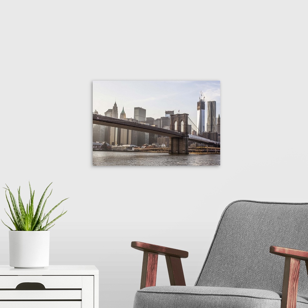 A modern room featuring A shot of Brooklyn Bridge with the New York City skyline in the background, including the One Wor...