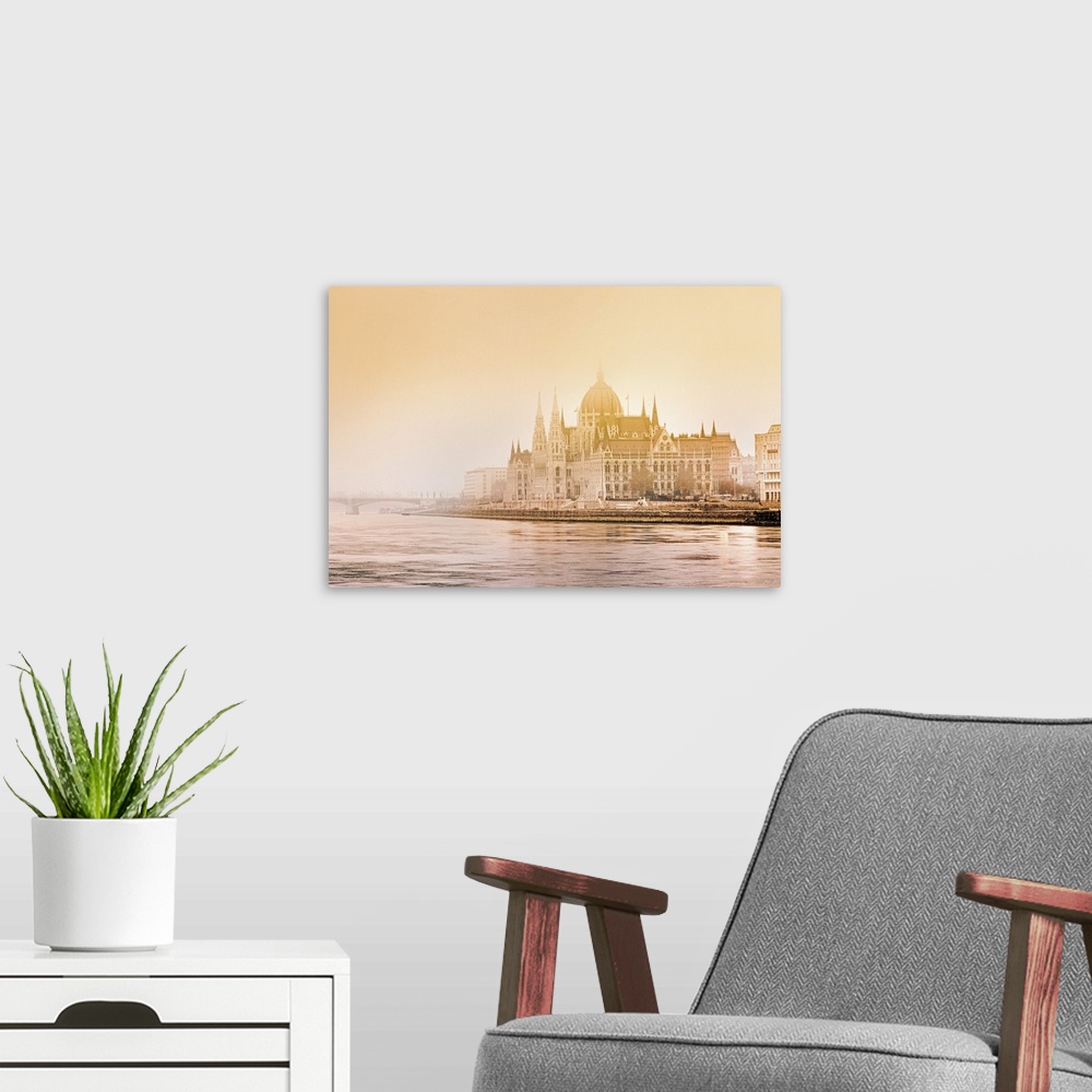 A modern room featuring Atmospheric winter conditions surround the Hungarian Parliament Building on the banks of the Danu...