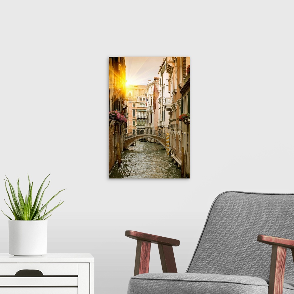A modern room featuring Large portrait wall hanging of buildings and a bridge in a canal in Venice, Italy.
