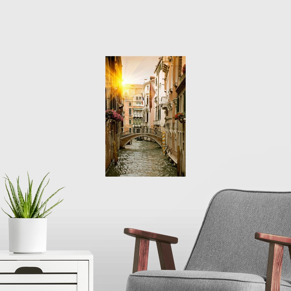 A modern room featuring Large portrait wall hanging of buildings and a bridge in a canal in Venice, Italy.