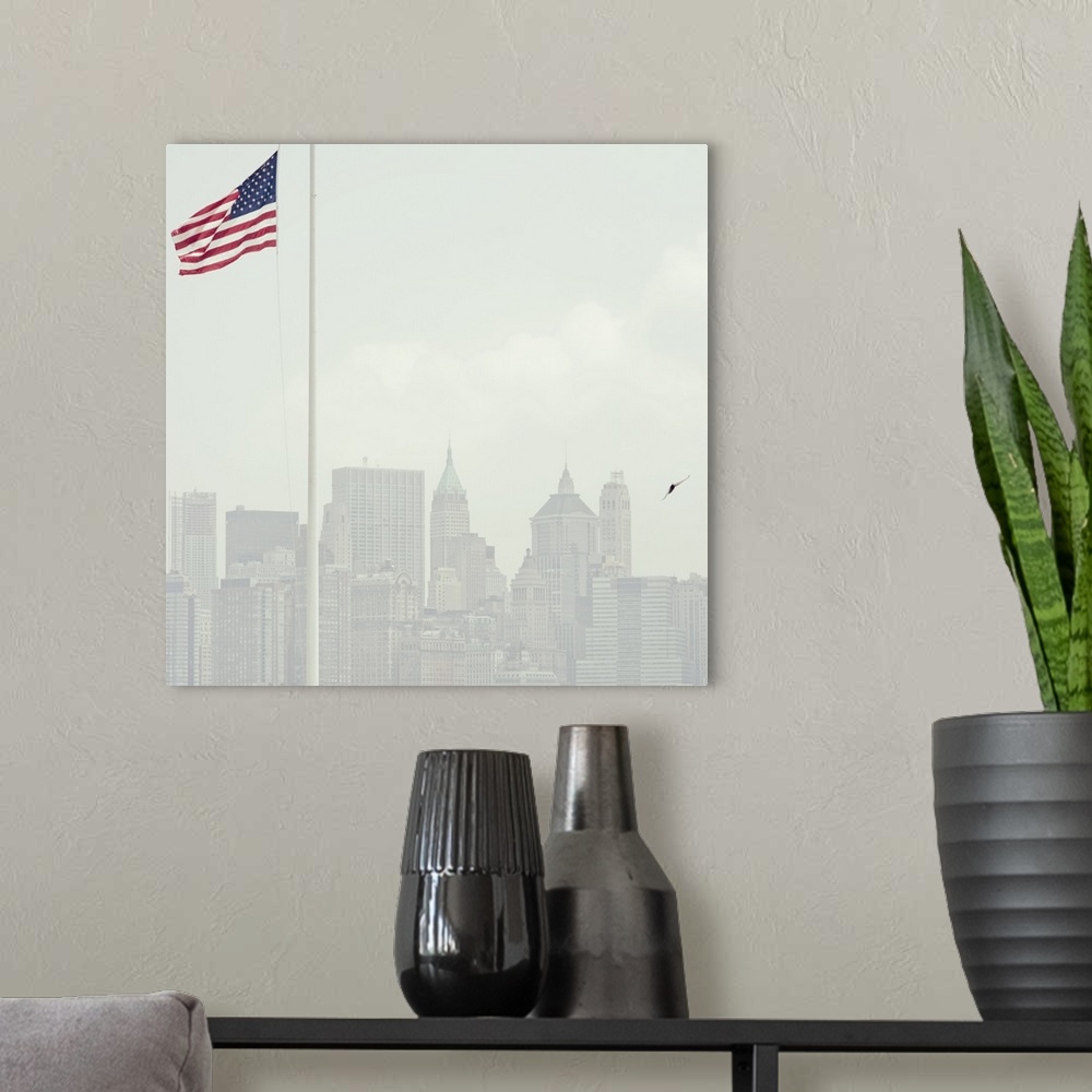 A modern room featuring Buildings of Manhattan with United States flag flying in foreground.
