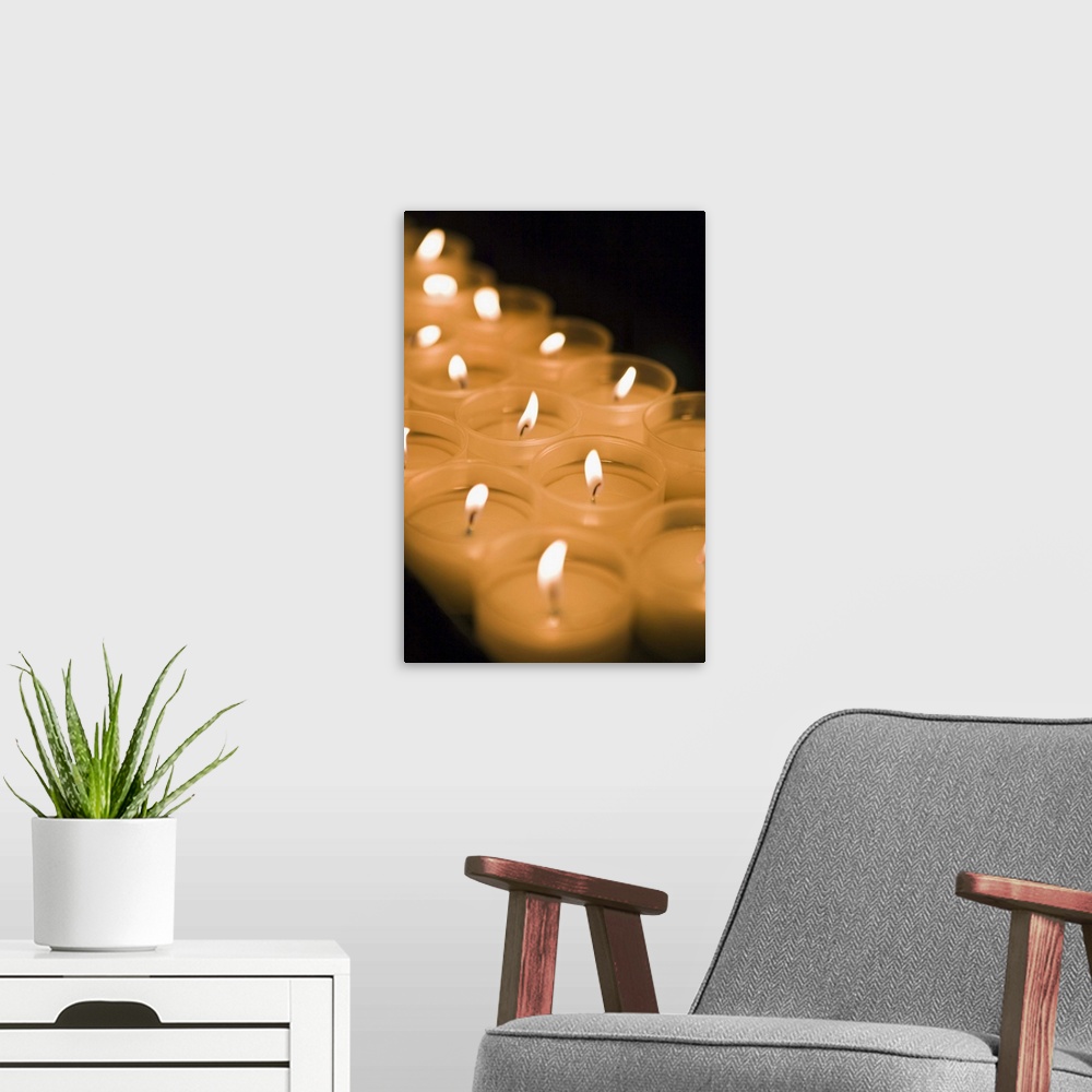 A modern room featuring Burning candles in darkness