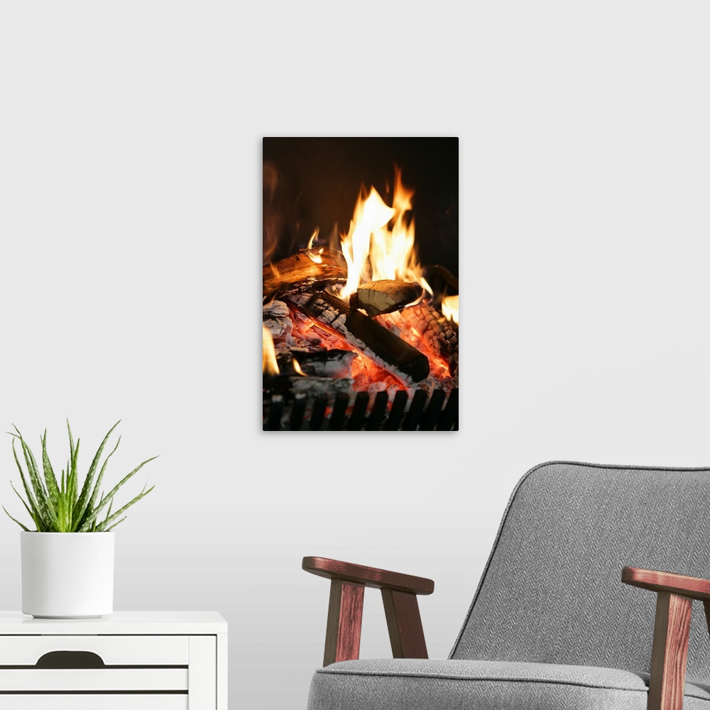 A modern room featuring Burning logs in fireplace