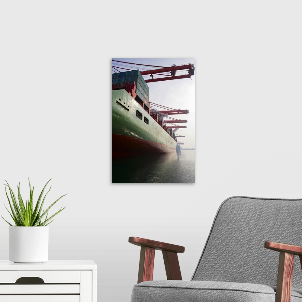 A modern room featuring Cargo ship at port being loaded.