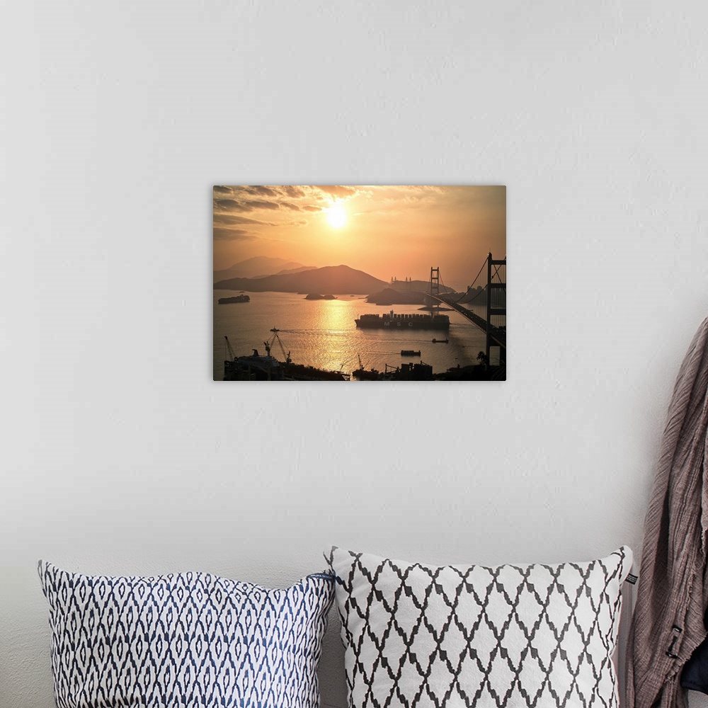 A bohemian room featuring Cargo vessel crossing the bridge at sunset.