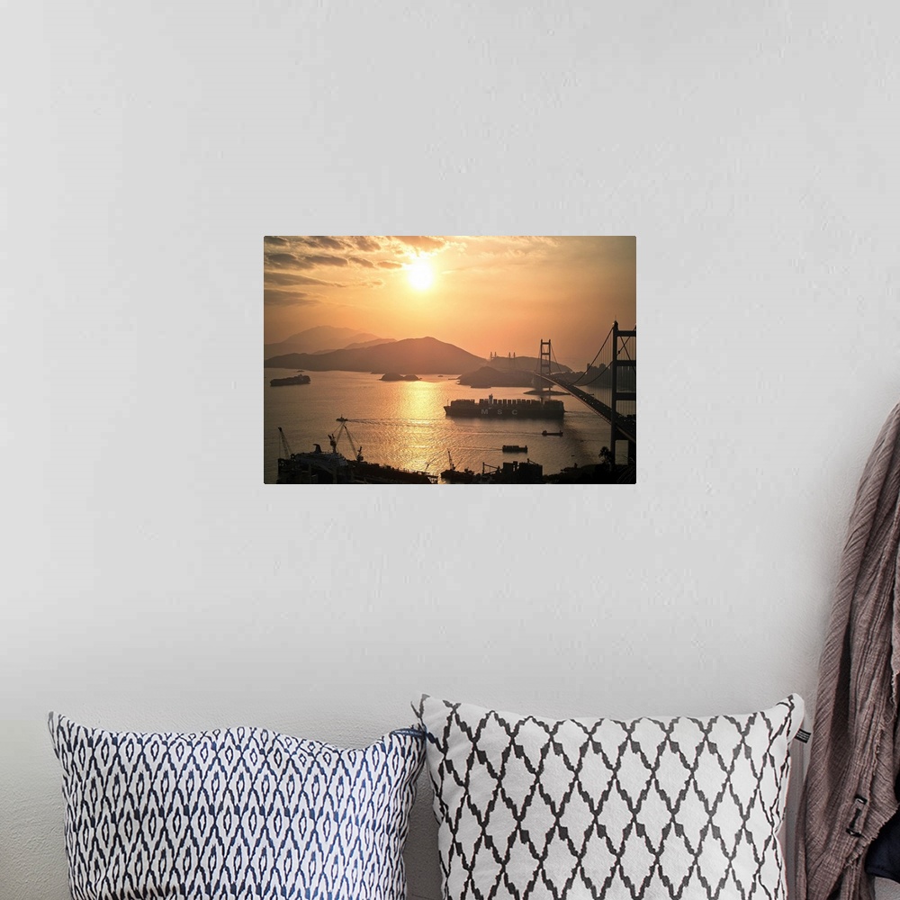 A bohemian room featuring Cargo vessel crossing the bridge at sunset.