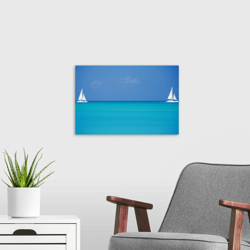 A modern room featuring Canvas print of two sailboats floating in clear ocean water with one on the left and one on the r...