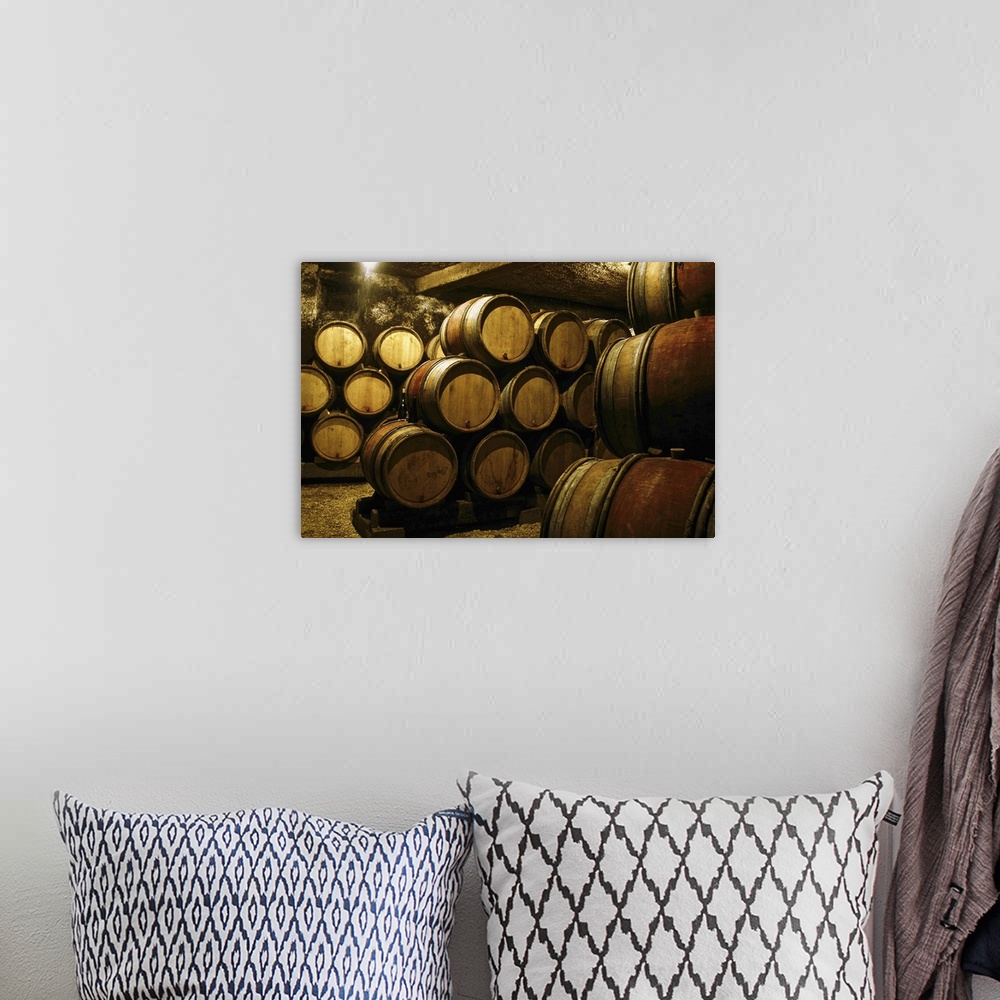 A bohemian room featuring Photograph of a cellar or basement full of barrels in storage stacked on top of one another. A si...