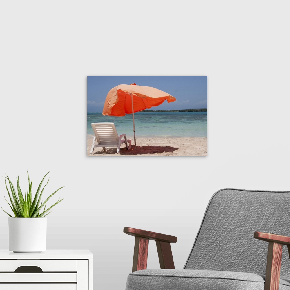 A modern room featuring Close-up of relaxing chair with parasol umbrella on beach.