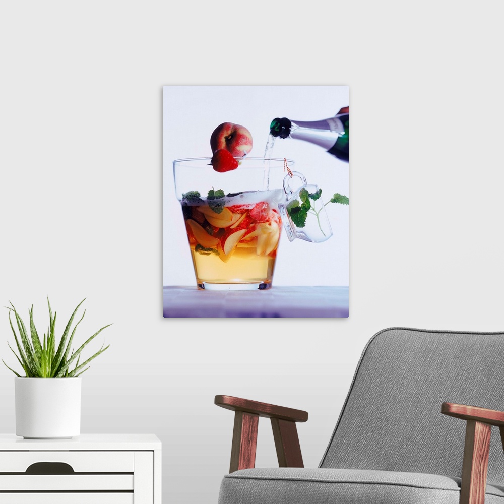 A modern room featuring Champagne pouring into fruit slice glass, close-up