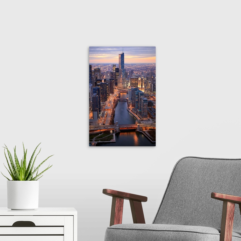 A modern room featuring Vertical panoramic photograph of city skyline at dusk.  Building lights are shining and there is ...
