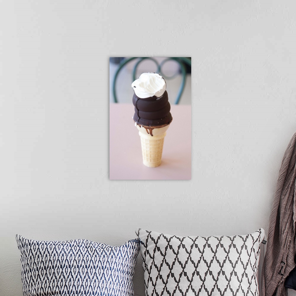 A bohemian room featuring Chocolate dipped ice cream cone with one bite out of it.