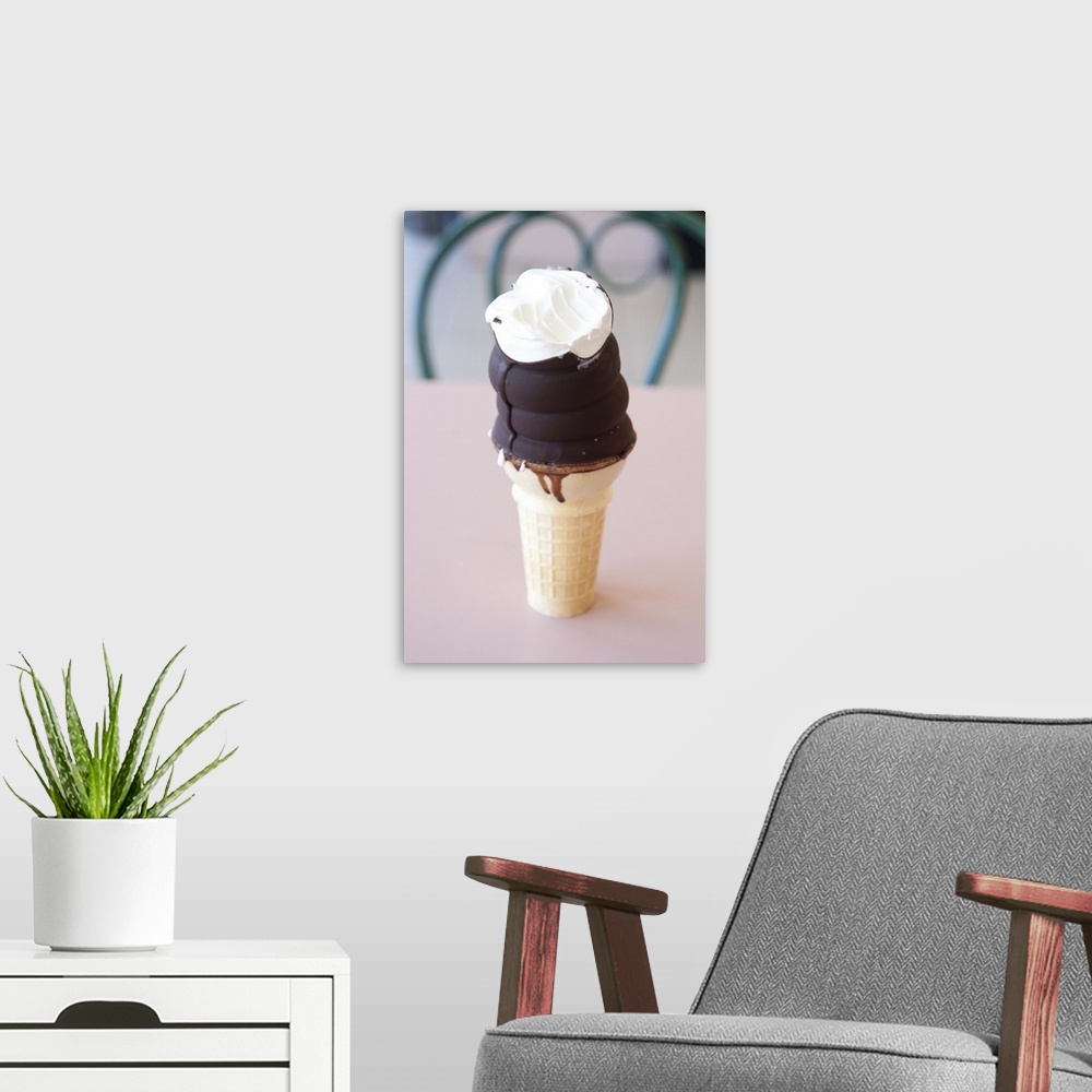 A modern room featuring Chocolate dipped ice cream cone with one bite out of it.