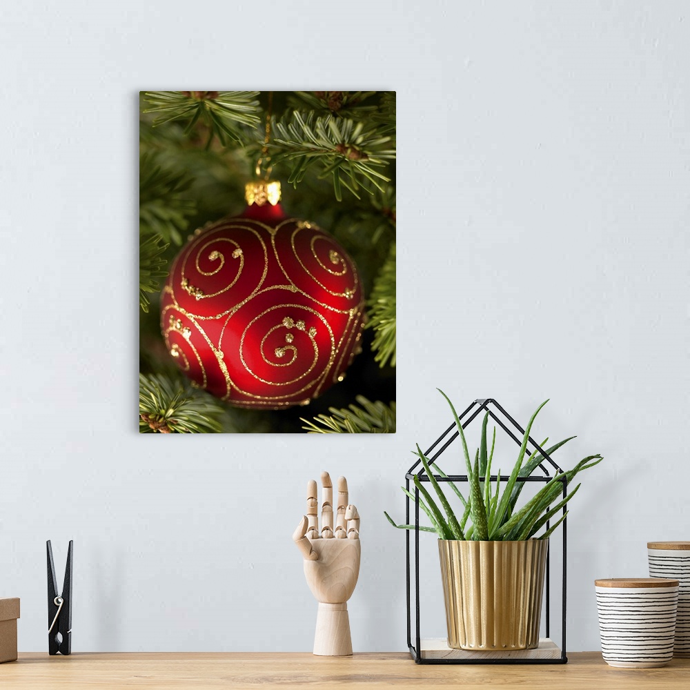 A bohemian room featuring Red bauble decoration hanging on Christmas tree.