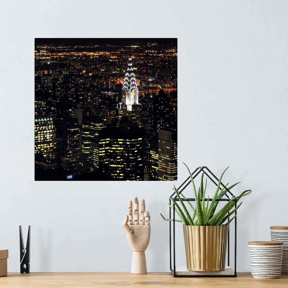 A bohemian room featuring Square photo art of NYC lit up at night.