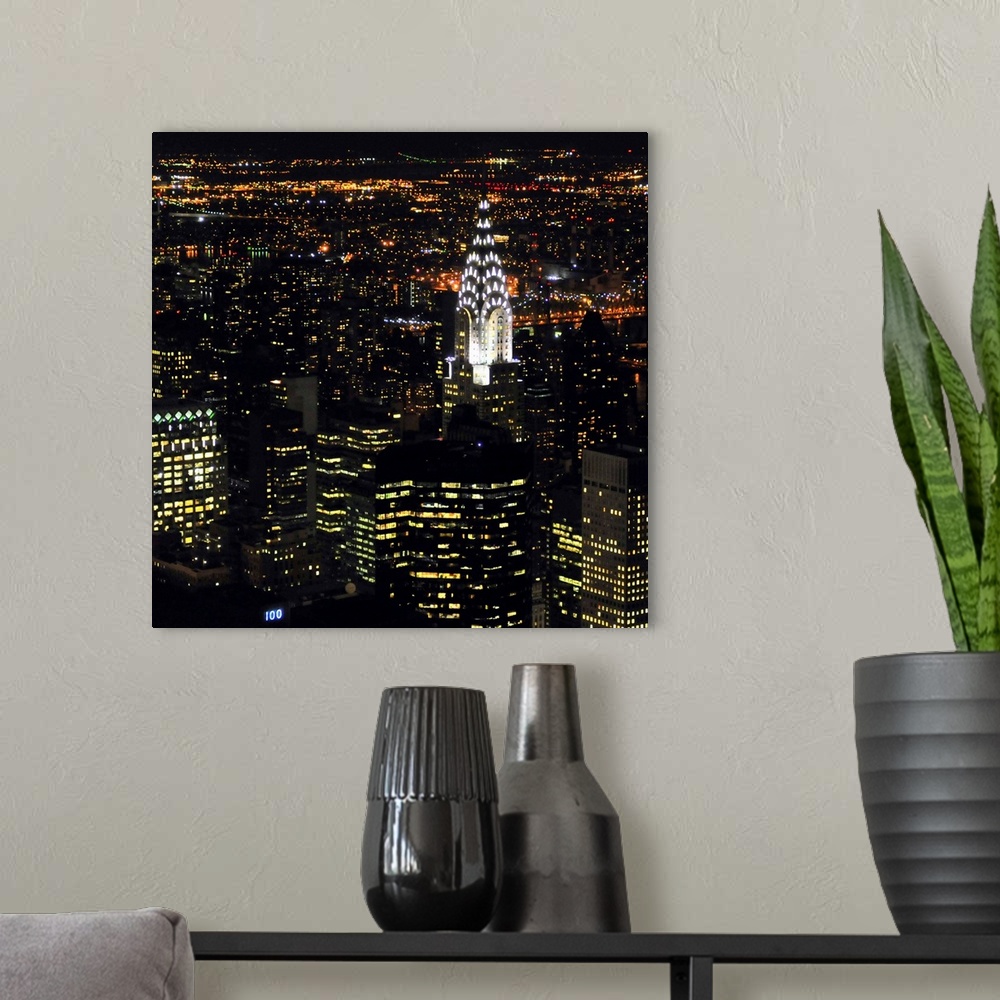 A modern room featuring Square photo art of NYC lit up at night.