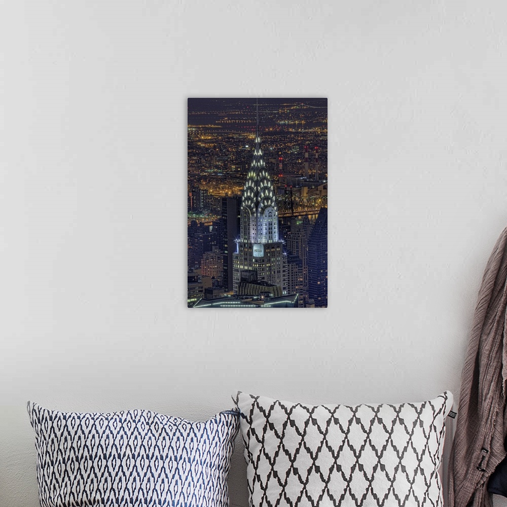 A bohemian room featuring Aerial vertical picture of the top of the Chrysler building lit up at night with the rest of down...
