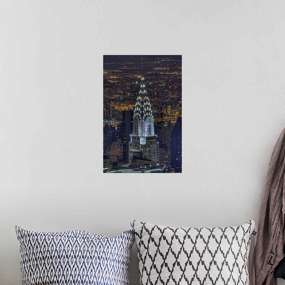 A bohemian room featuring Aerial vertical picture of the top of the Chrysler building lit up at night with the rest of down...