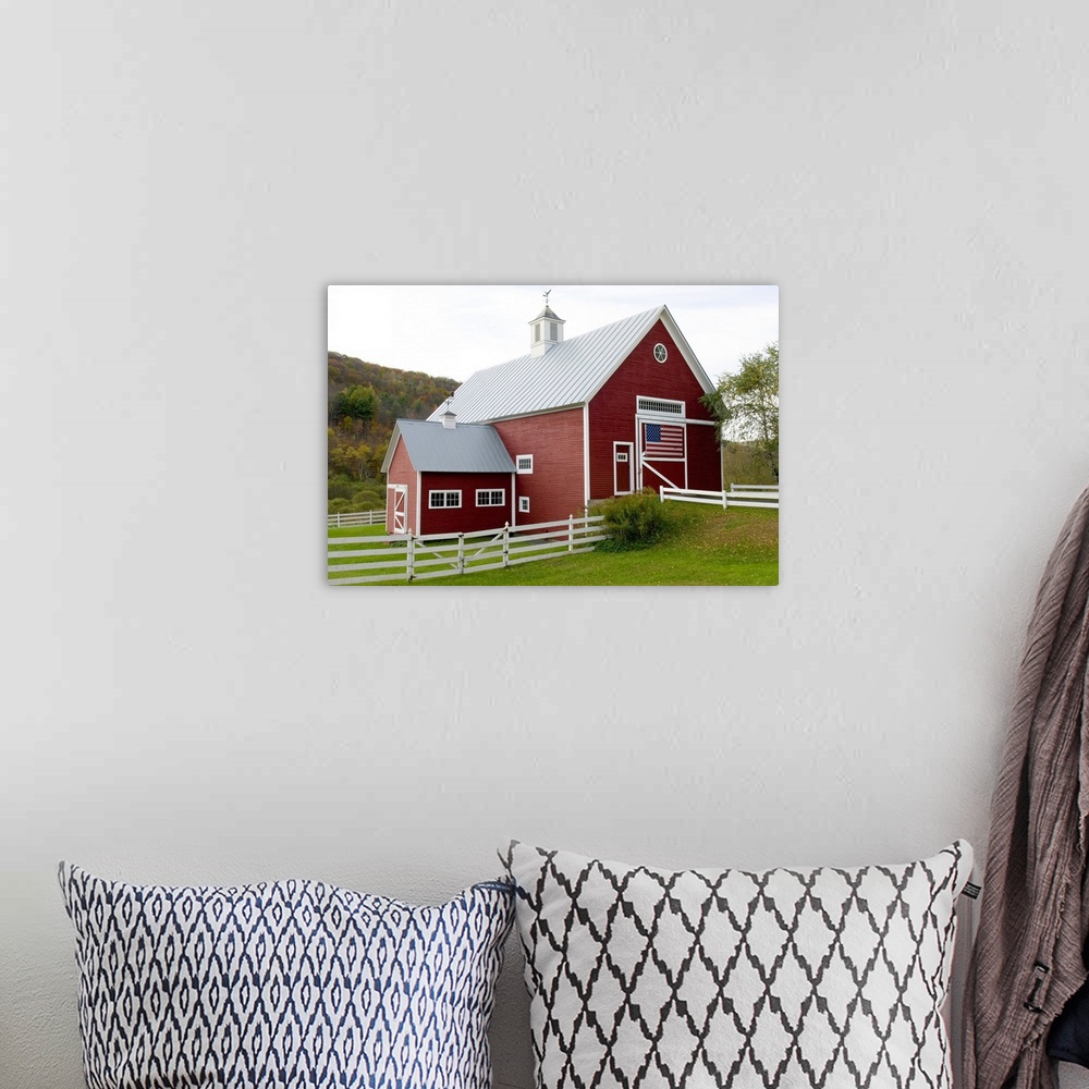 A bohemian room featuring Classic New England farm with red barn and white fence. American flag on barn door. Vermont. USA