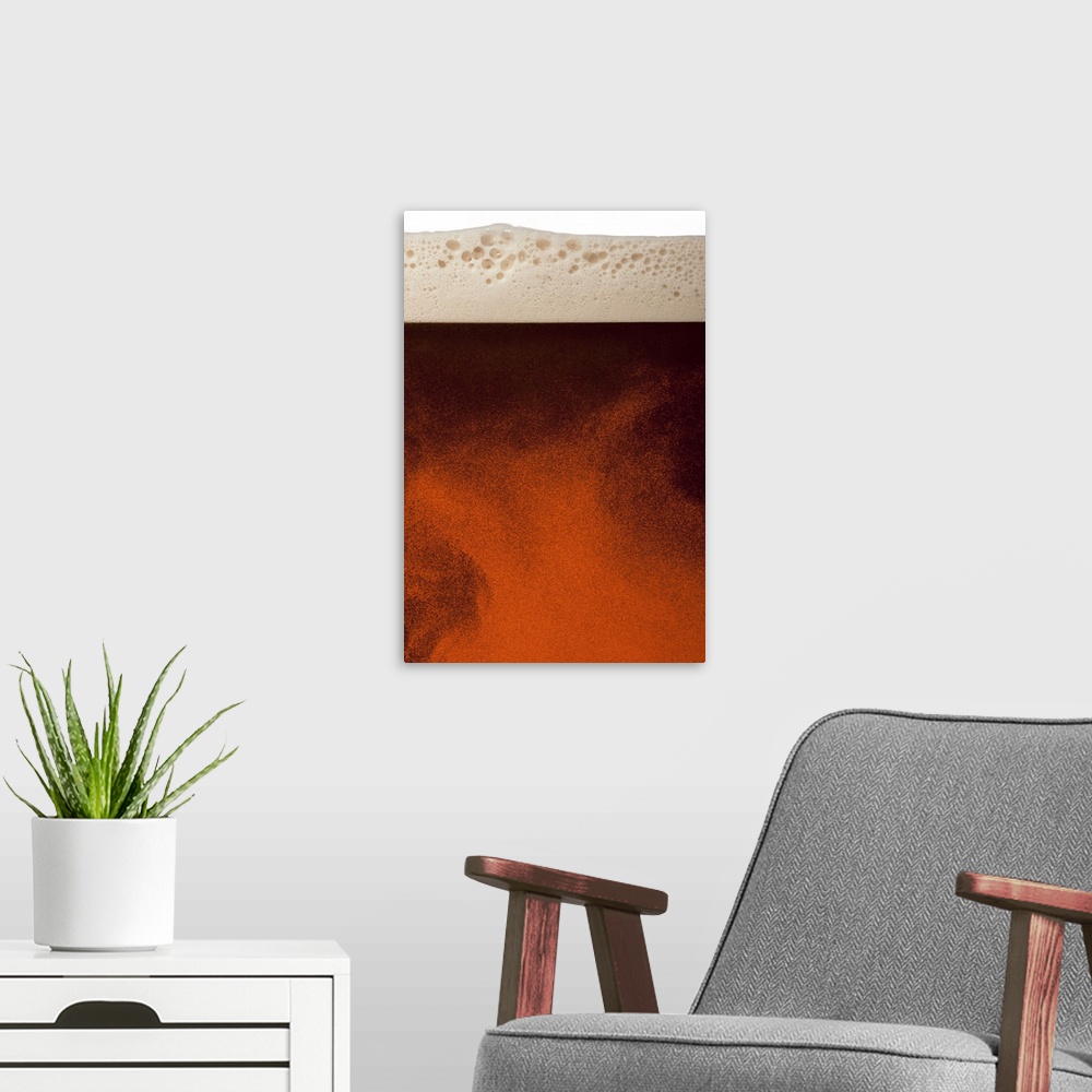 A modern room featuring Close up image of amber colored beer with frothy head, swirling bubbles and copy space