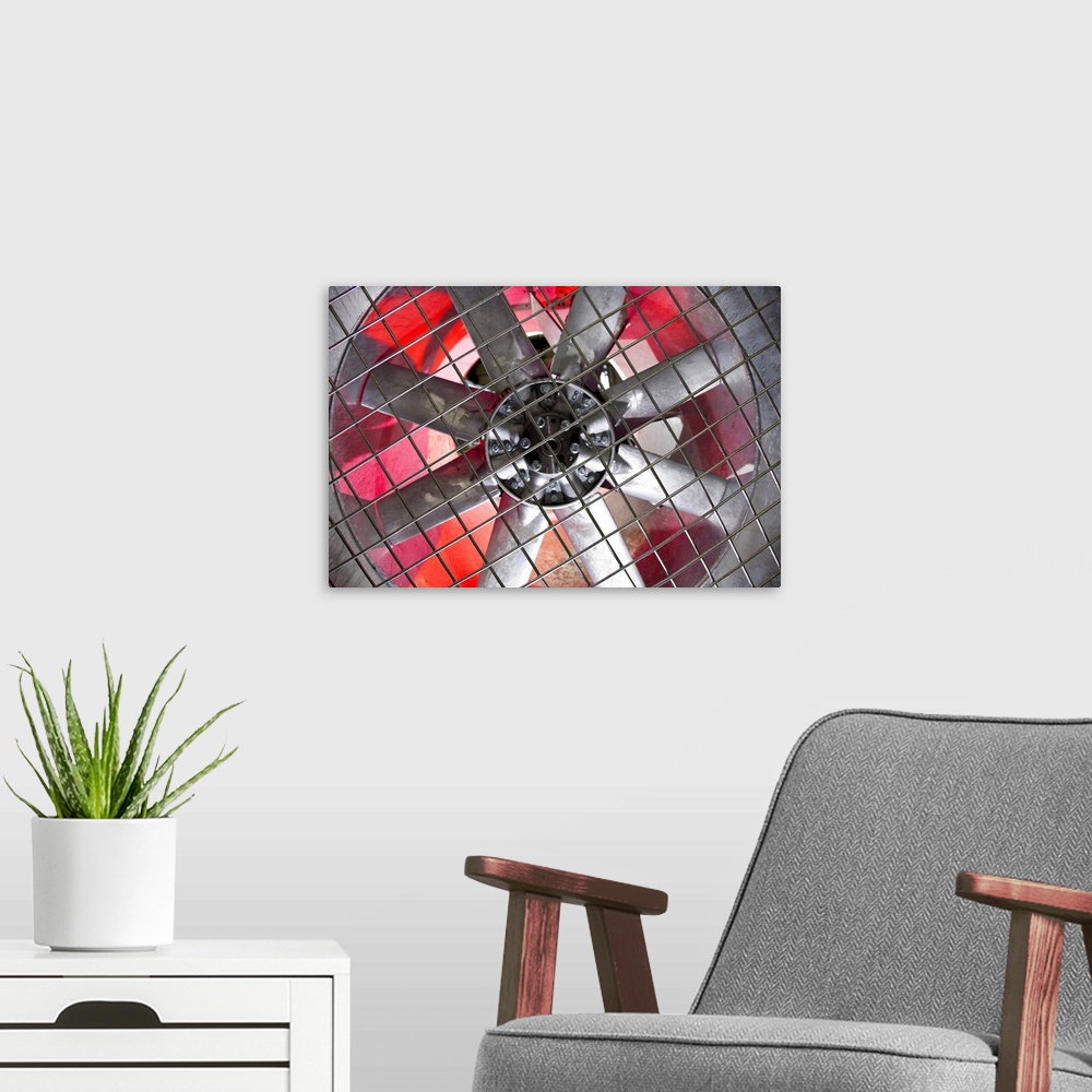 A modern room featuring Close-up of an industrial ventilation fan with red hues lighting up the back.
