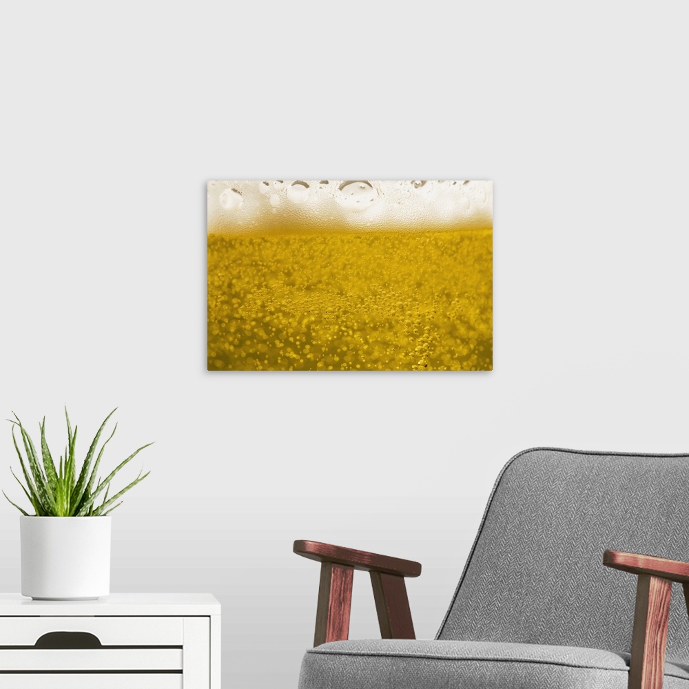 A modern room featuring close-up of beer bubbles and foam in a glass