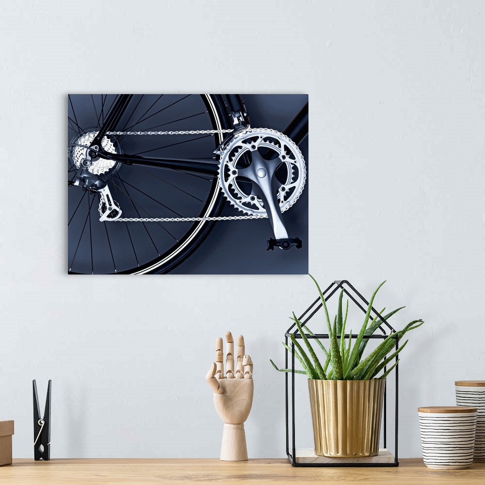 A bohemian room featuring Oversized, horizontal, close up photograph of part of the back wheel, the chain, gears and pedal ...