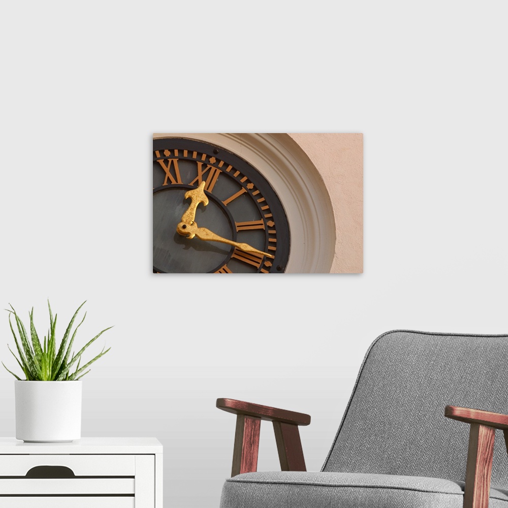A modern room featuring Landscape, large, close up photograph of a partial clock on a tower.  The large golden hands of t...