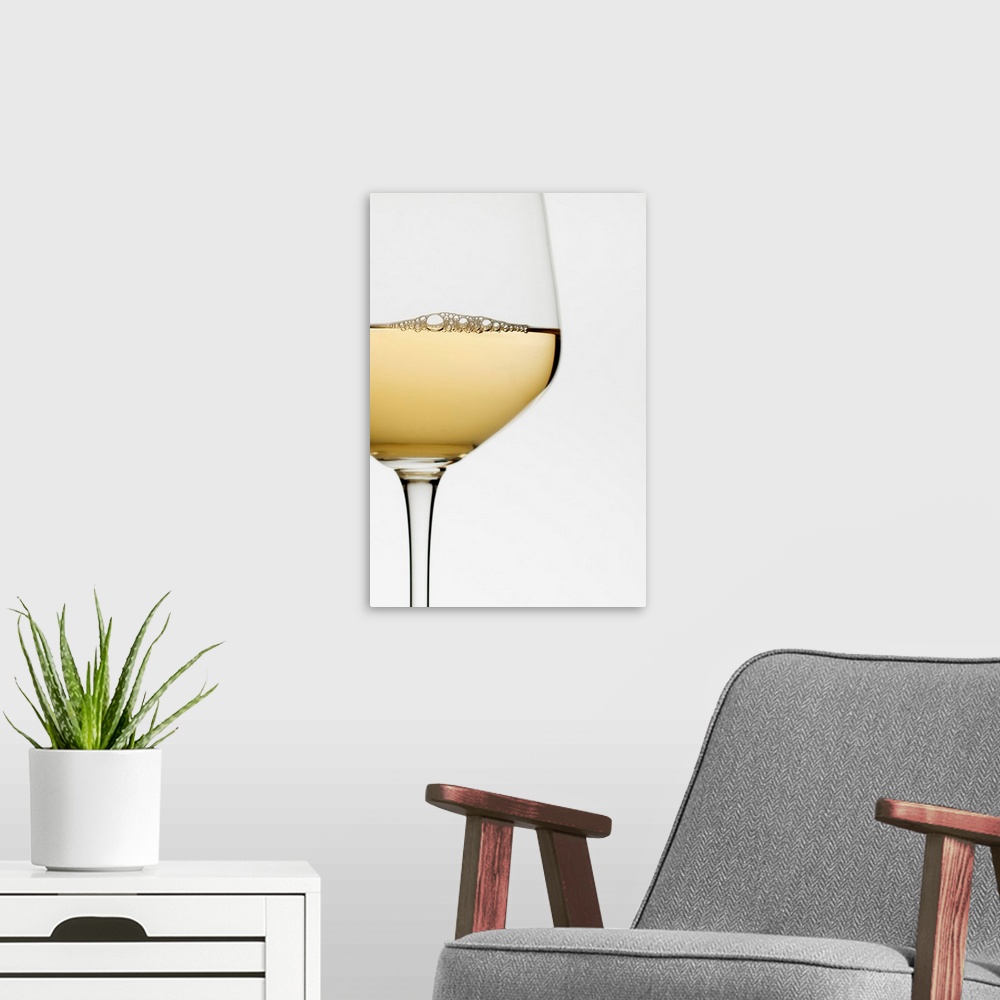 A modern room featuring Close up of glass of white wine on white background