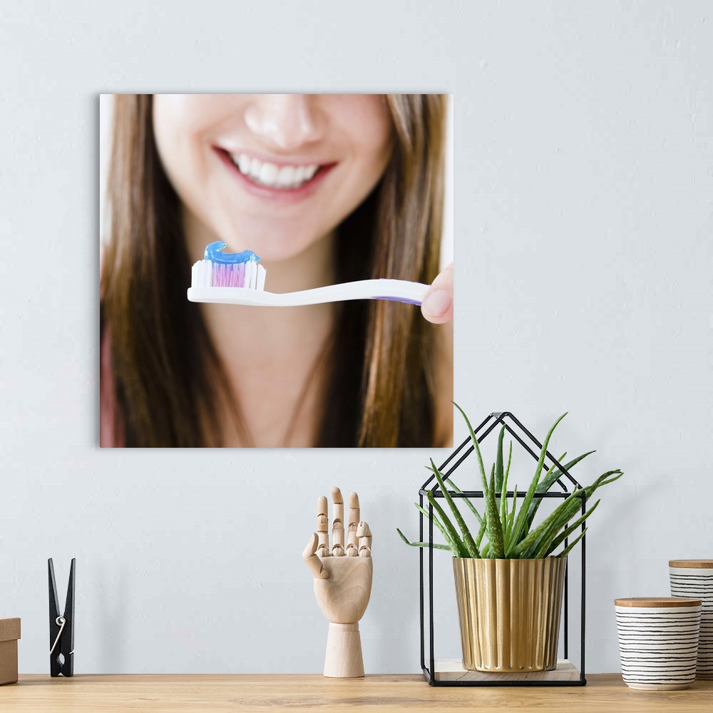 A bohemian room featuring Close-up of smiling young woman holding toothbrush