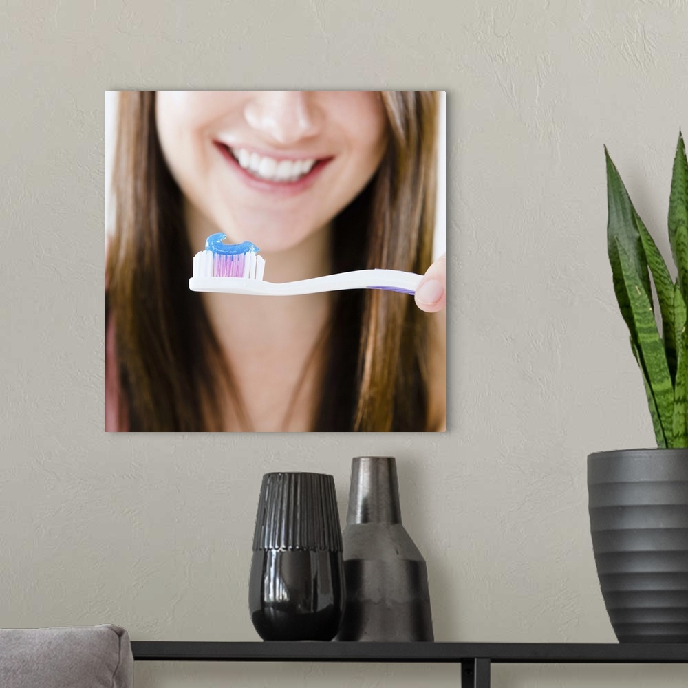 A modern room featuring Close-up of smiling young woman holding toothbrush
