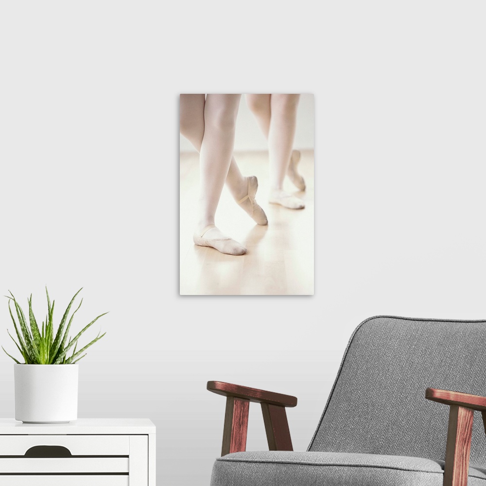 A modern room featuring close-up of two ballet dancer's feet