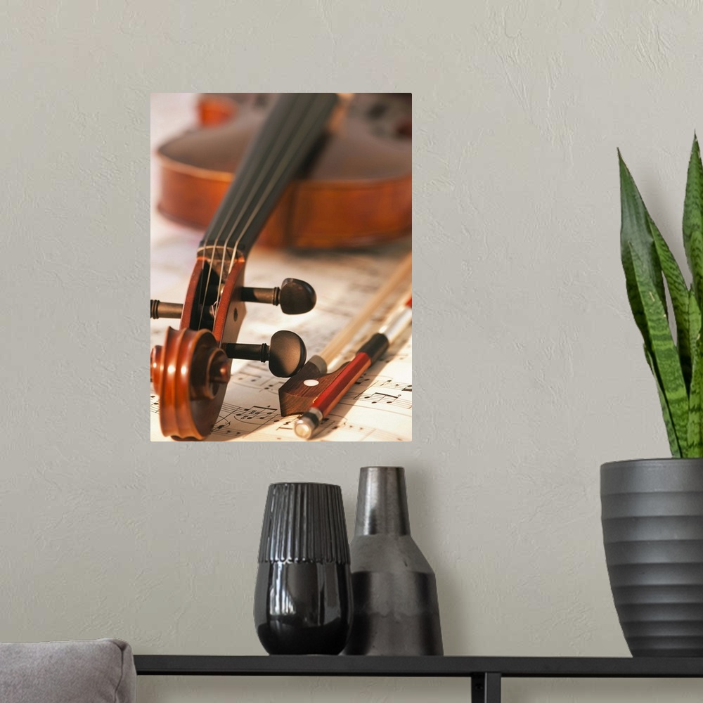 A modern room featuring Close up of violin scroll and bow on sheet music