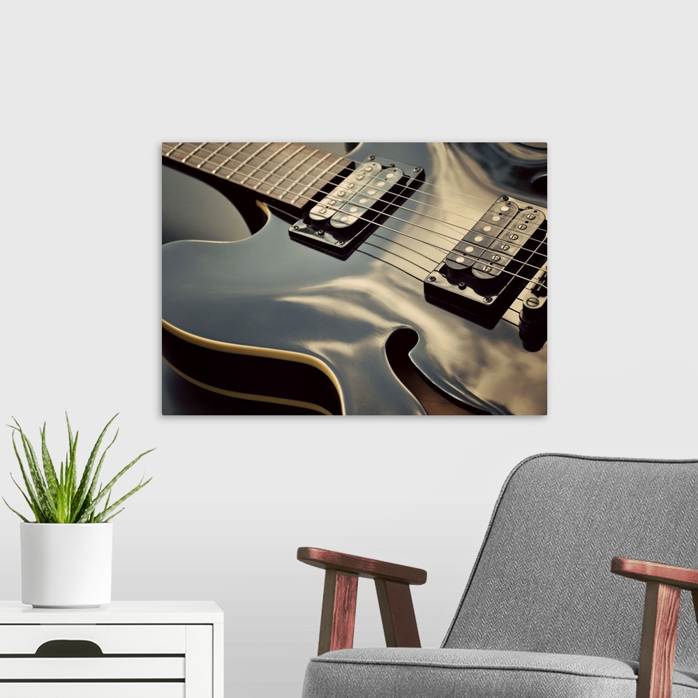 A modern room featuring Close up shot of black guitar.