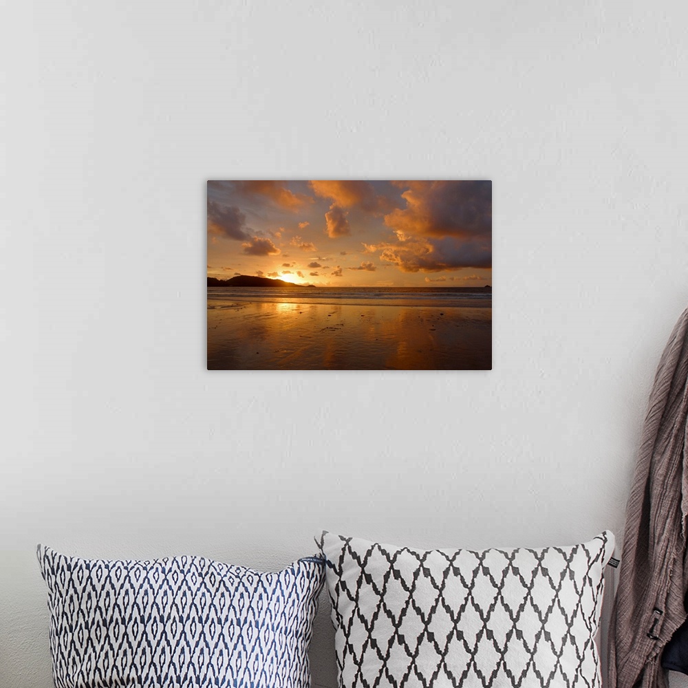 A bohemian room featuring Cloudy sky over beach at sunset