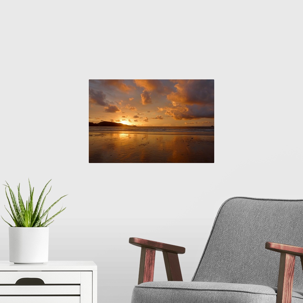 A modern room featuring Cloudy sky over beach at sunset